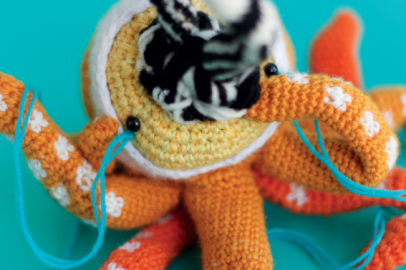 Crocheted doll called Amigurumi. The doll has the shape of an octopus with many heads and snakes coming out from its mouth.